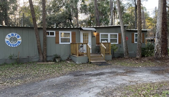 Step into this cozy 2-bedroom cabin nestled in the tranquil woods. The main living area offers comfy seating, including a pull-out futon for additional sleeping space. An efficiency kitchen awaits your culinary adventures, equipped with essentials fo